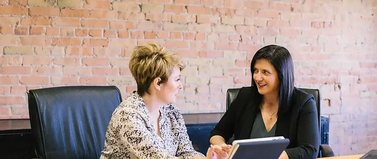 Two women discussing documents