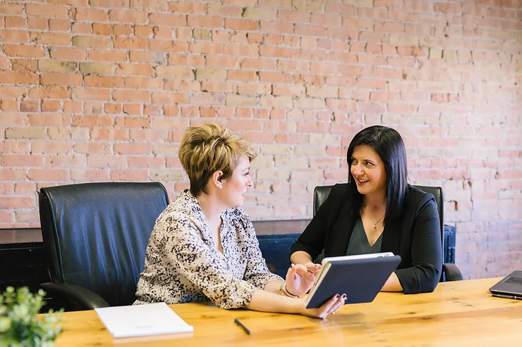 Two women discussing documents