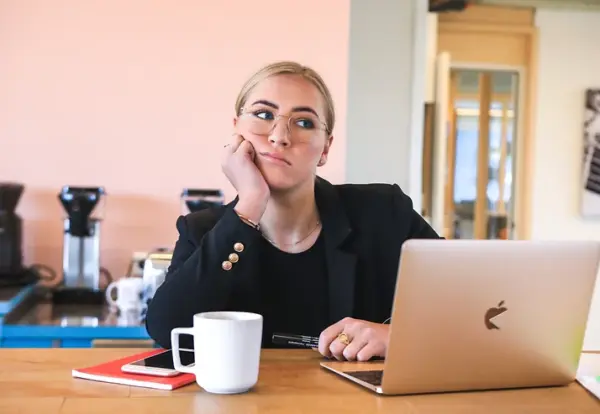 woman looking bored sitting at laptop