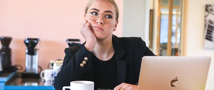 woman looking bored sitting at laptop