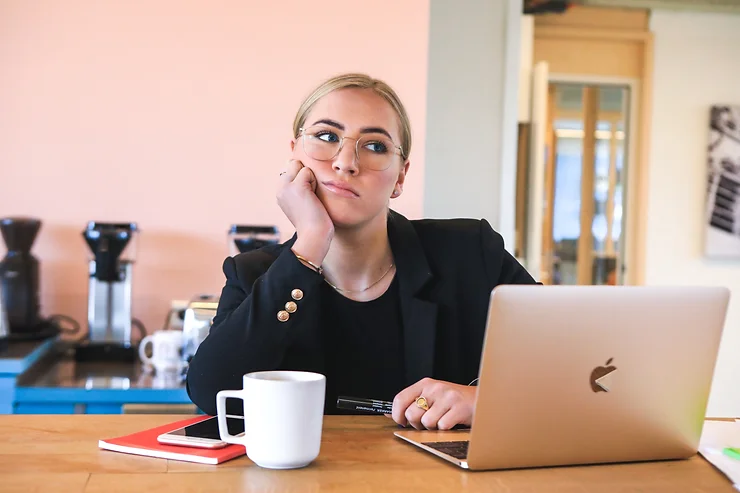 woman looking bored sitting at laptop