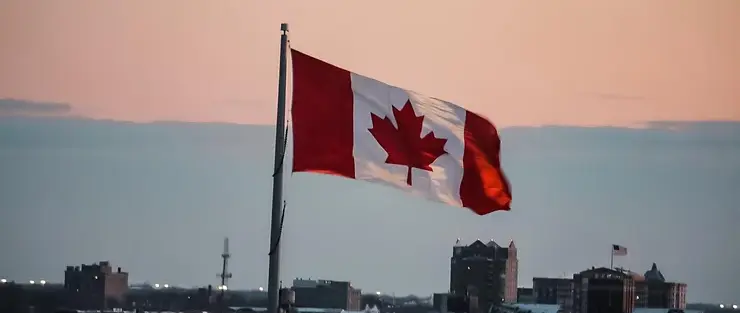 canadian flag flying at dusk