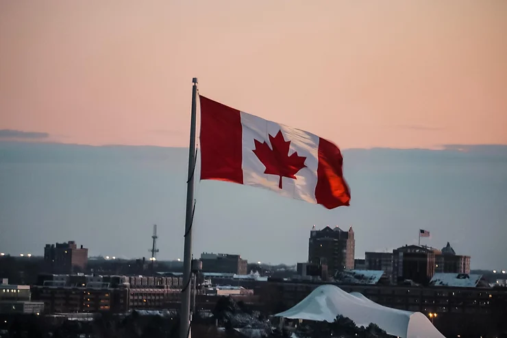 canadian flag flying at dusk